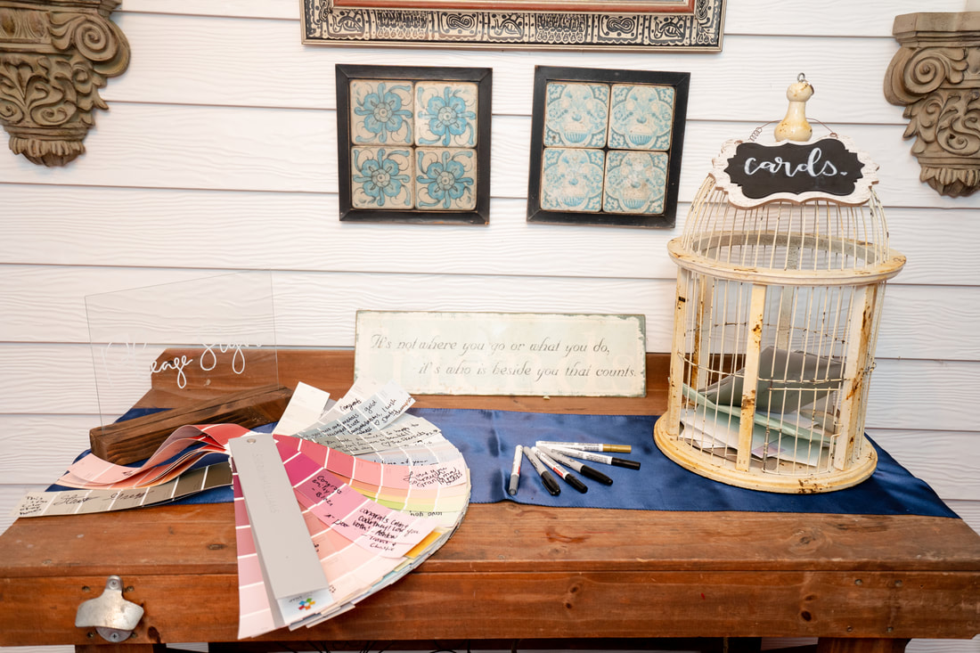 guestbook on farmhouse table with paint chip deck and white bird cage for cards