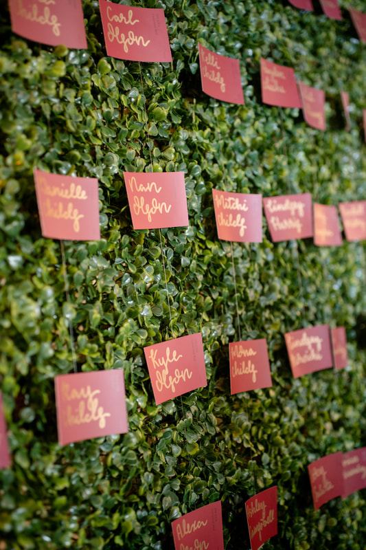 paint chips with guests' names on greenery wall