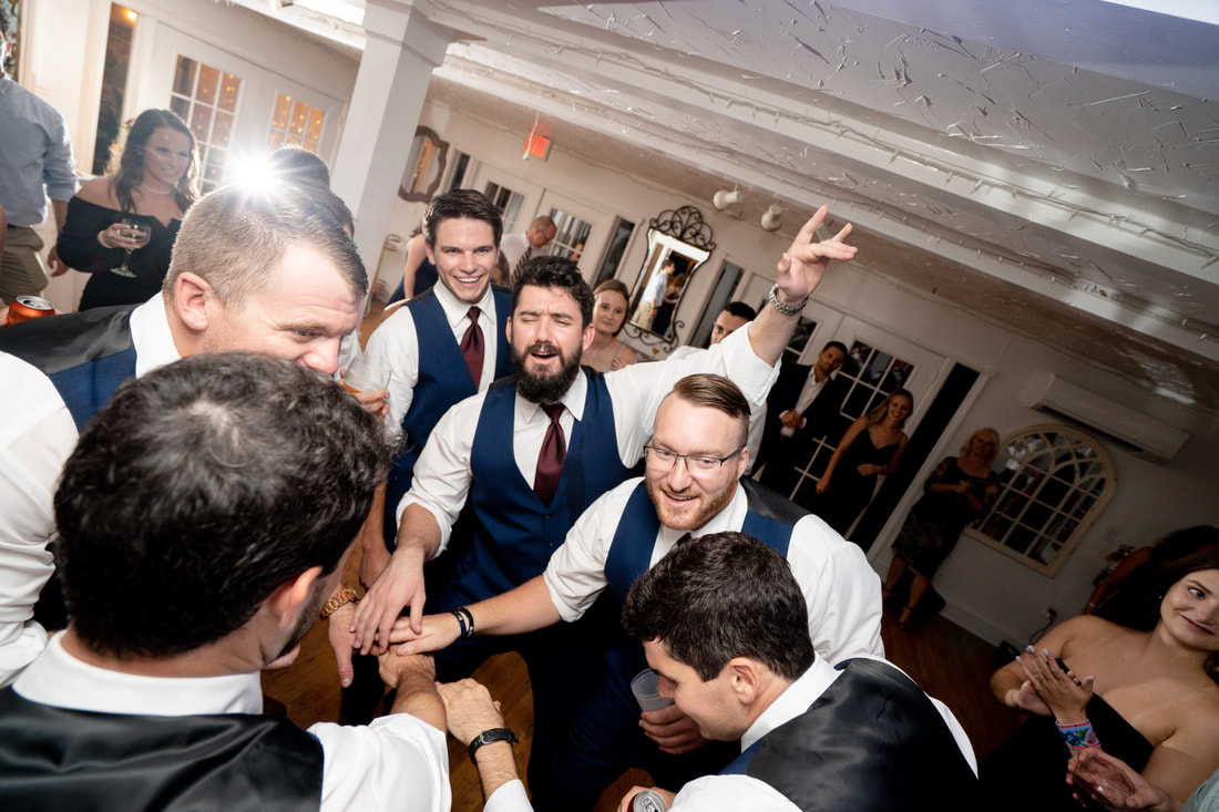 groomsmen dancing in a circle in carriage house