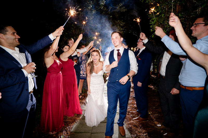 bride and groom walking out during sparkler grand exit as it sprinkles