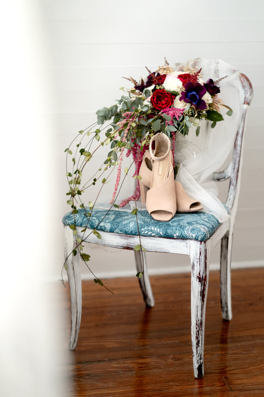 bridal bouquet, veil, and shoes on rustic blue wooden chair