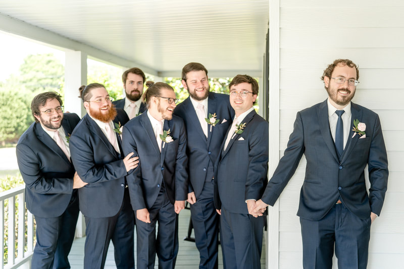 groomsmen fake first look around farmhouse porch with groom