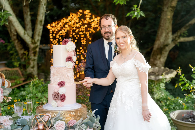 bride and groom cutting 3-tier pink wedding cake