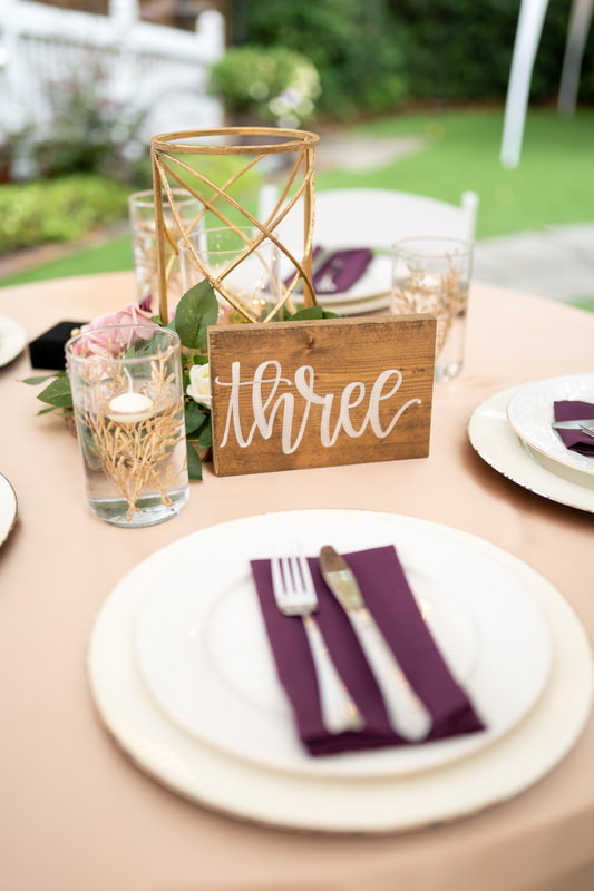 wedding reception table with champagne overlay and purple napkins