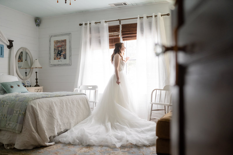 bride posing in white farmhouse bed room