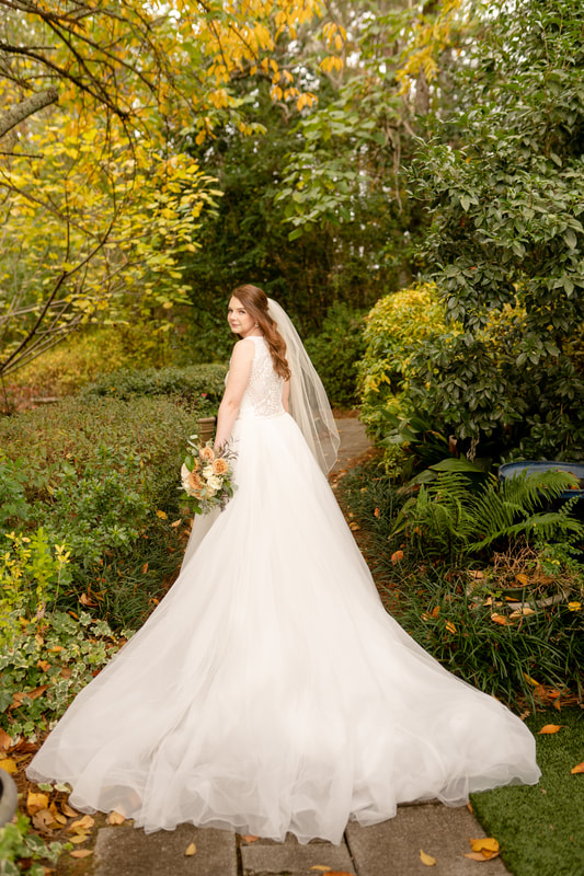 bride with large dress standing in garden path
