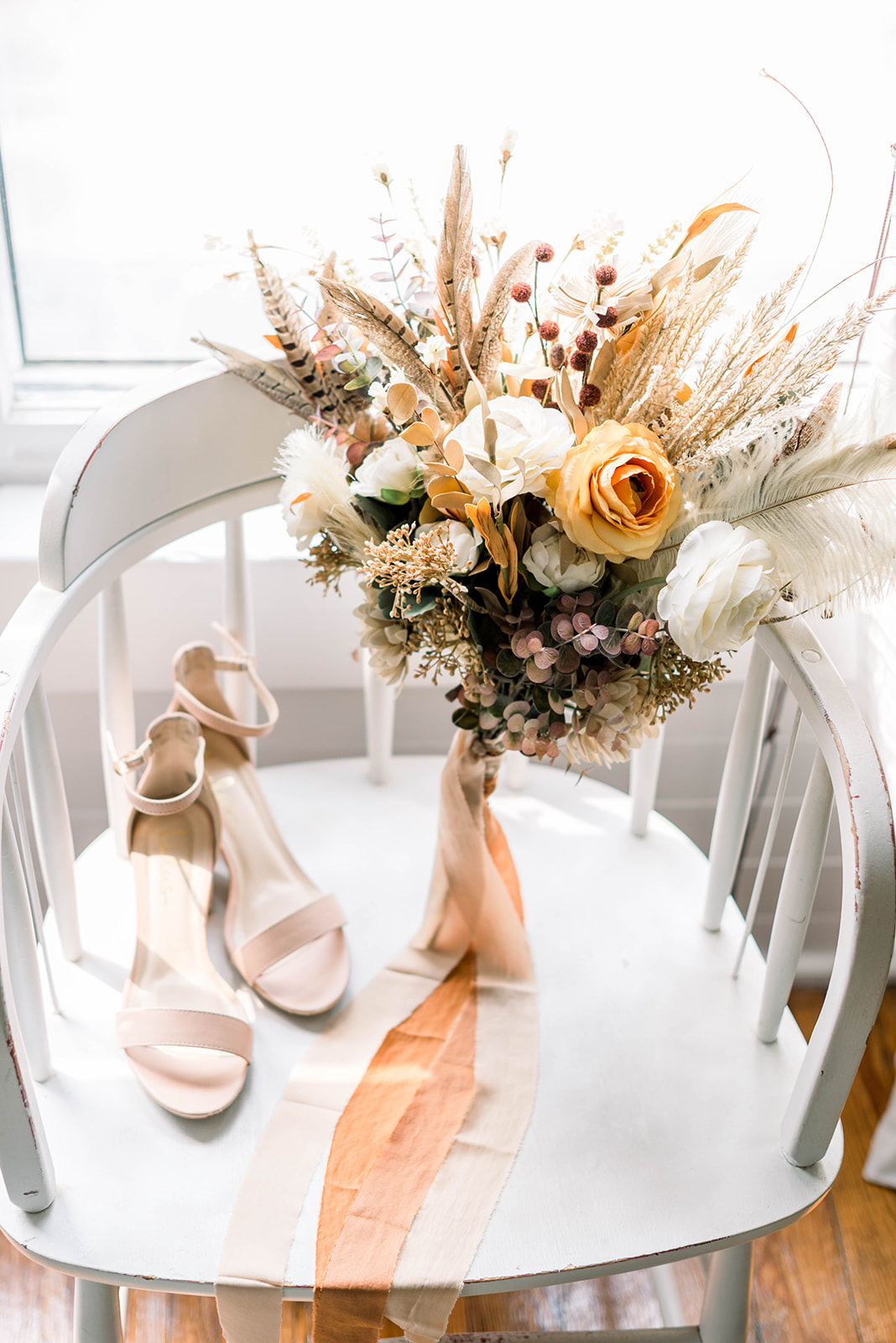 boho bouquet plus neutral colored heels on white chair