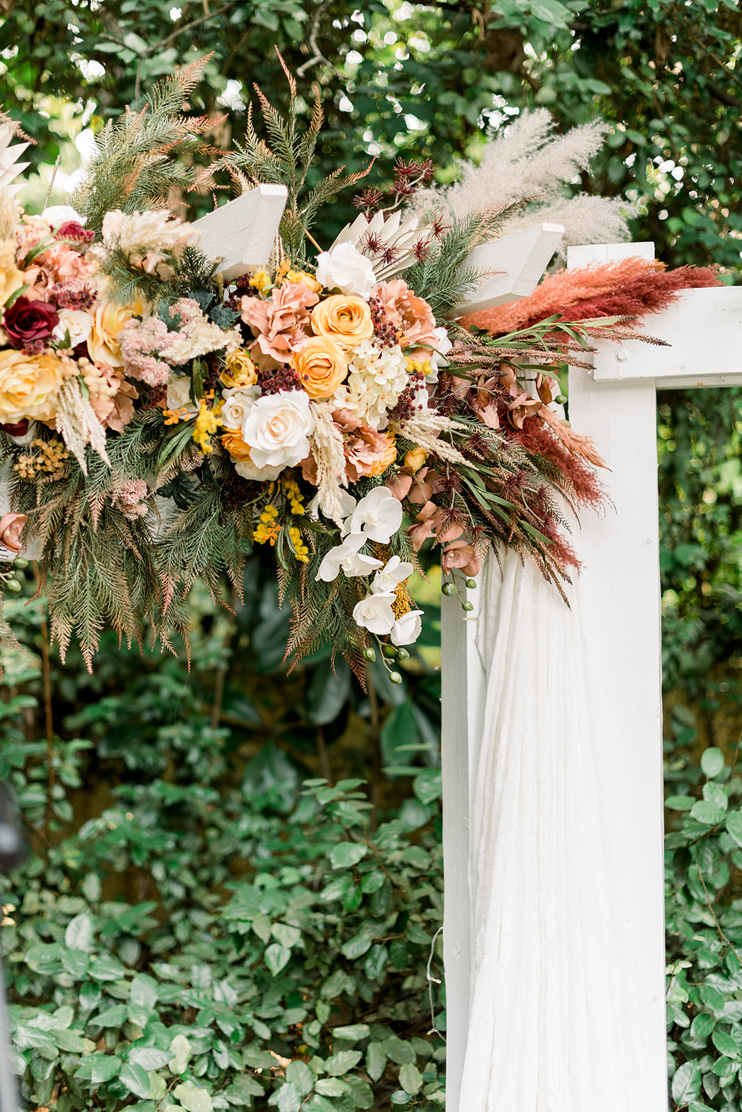 boho garden altar with greenery, warm-toned florals, and pampas grass