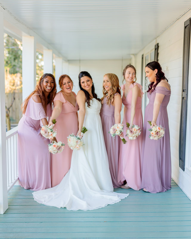 pink and purple bridesmaids dresses on farmhouse porch
