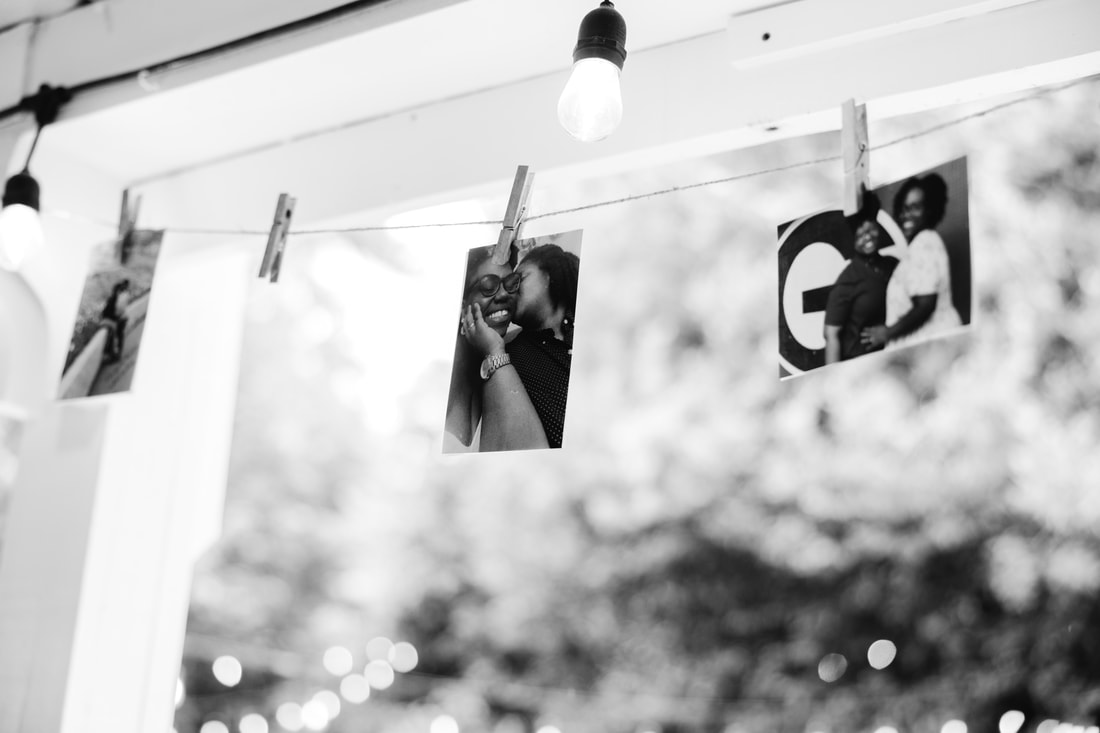 Black and white shot of a couple's photos hanging on twine outside the Carriage House