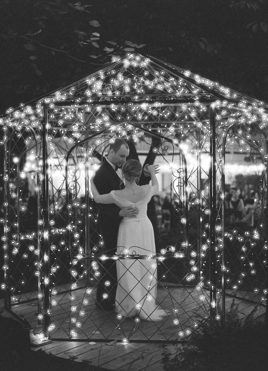 black and white film photo of bride and groom's first dance in gazebo