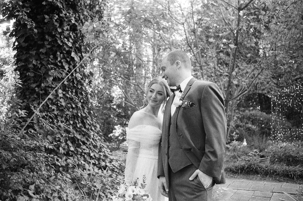 black and white photo of newlyweds in garden