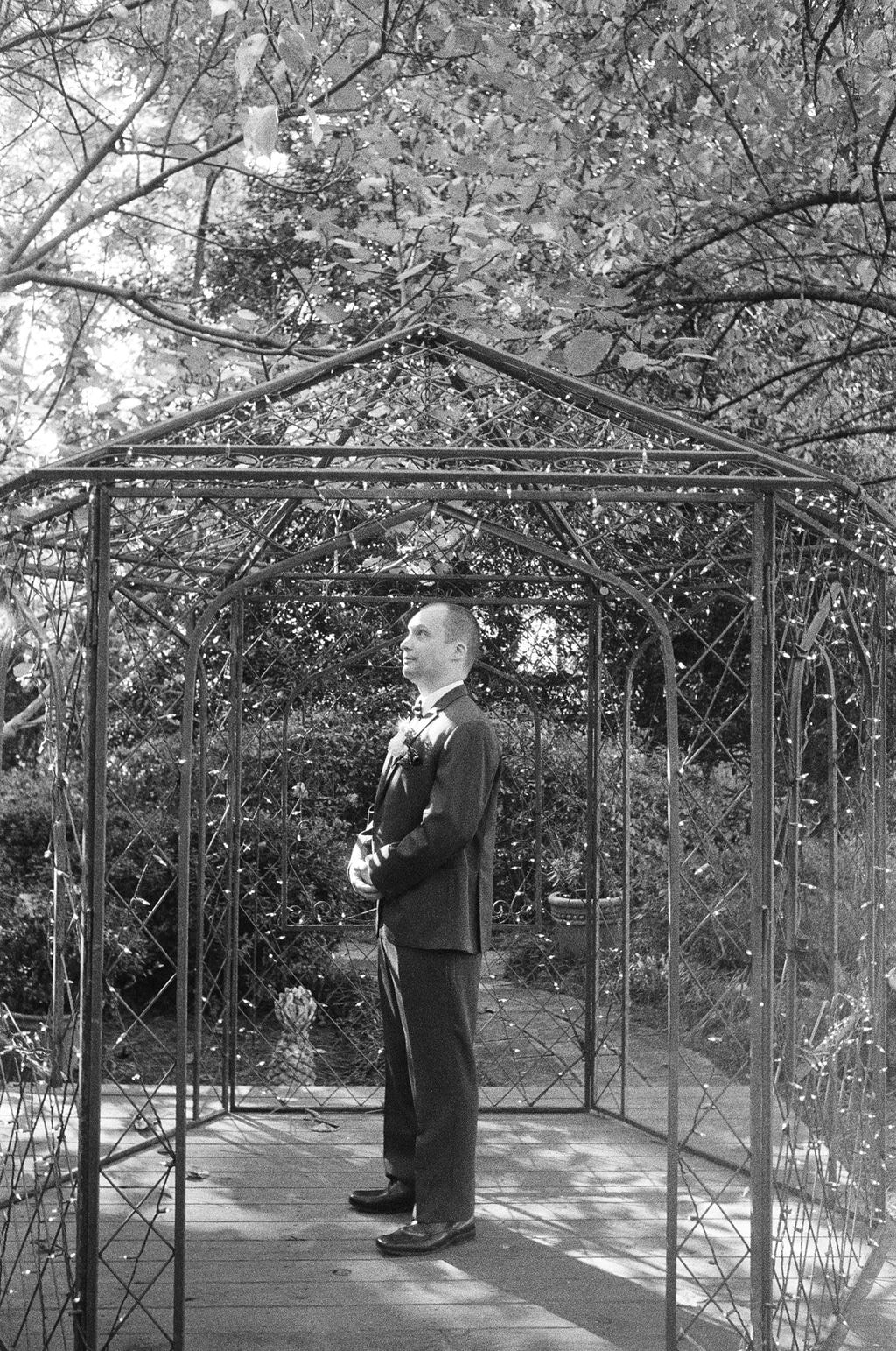 black and white film of groom in gazebo