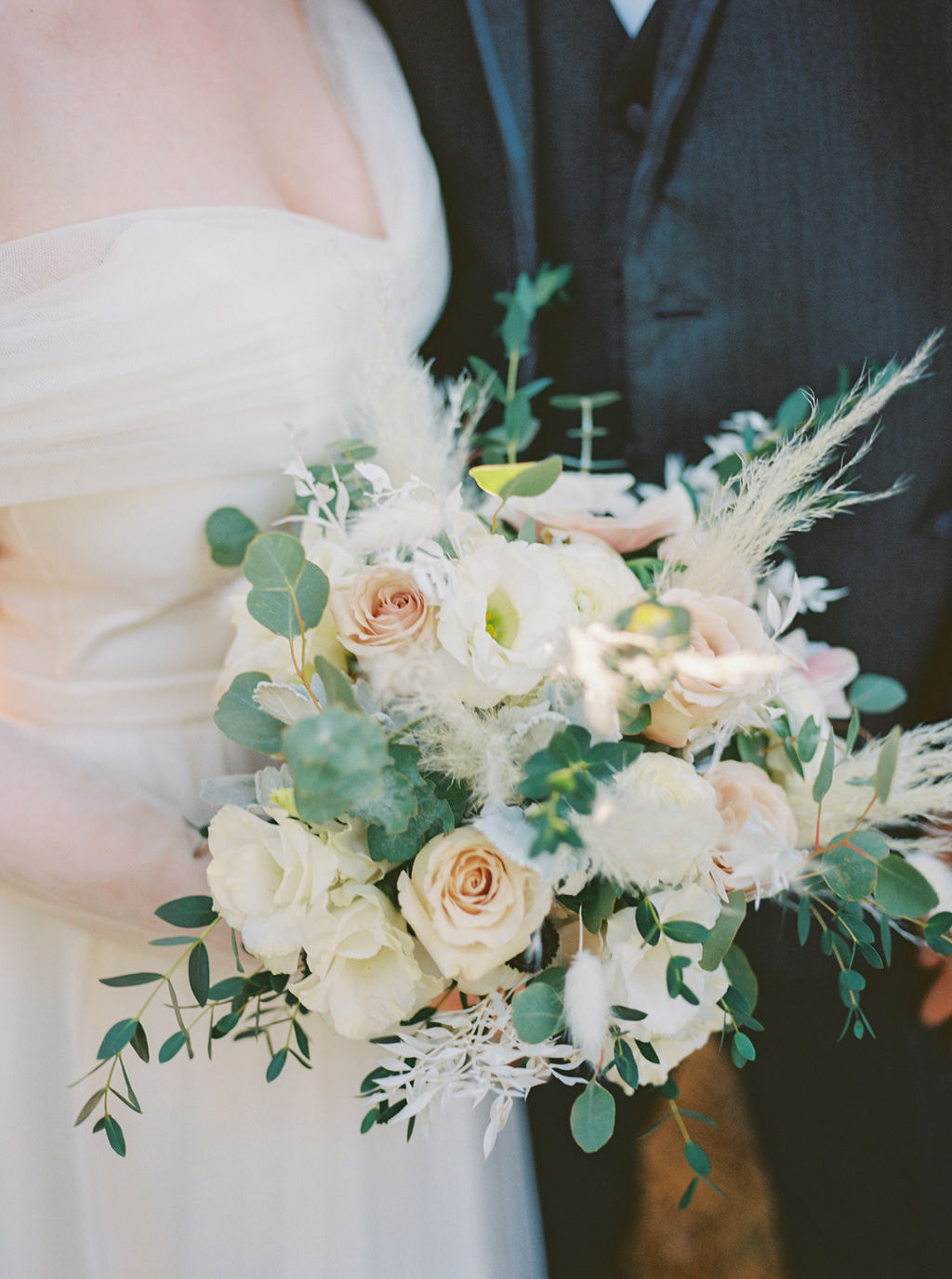 closeup of bride's bouquet with eucalyptus, neutral flowers, and pampas grass