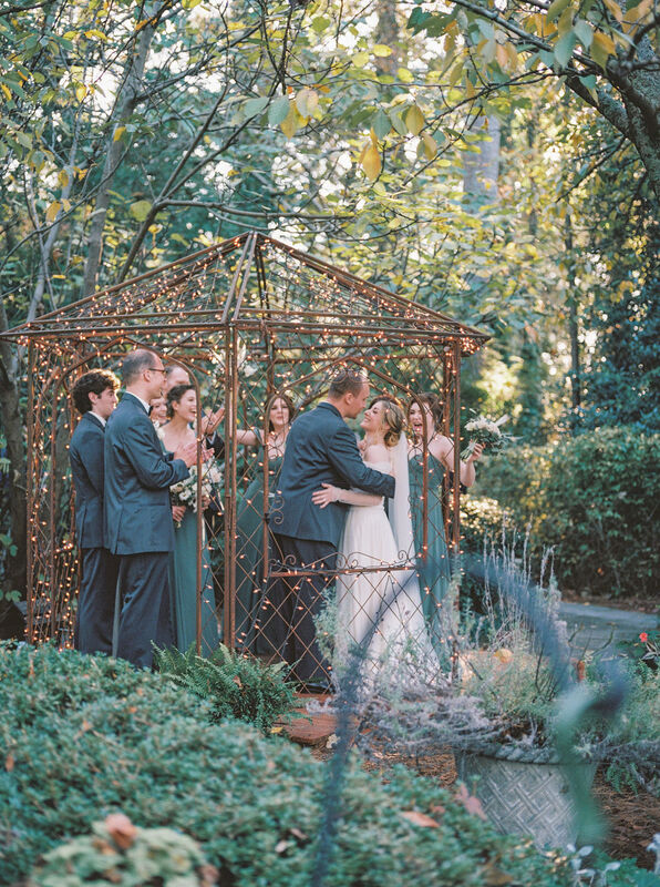 couple and wedding party in garden gazebo
