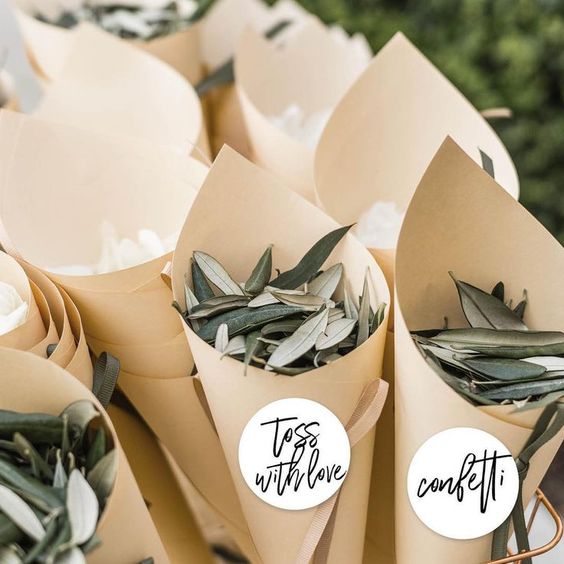 Small eucalyptus leaves in paper cones used as confetti to toss during a grand exit for an eco-friendly wedding.
