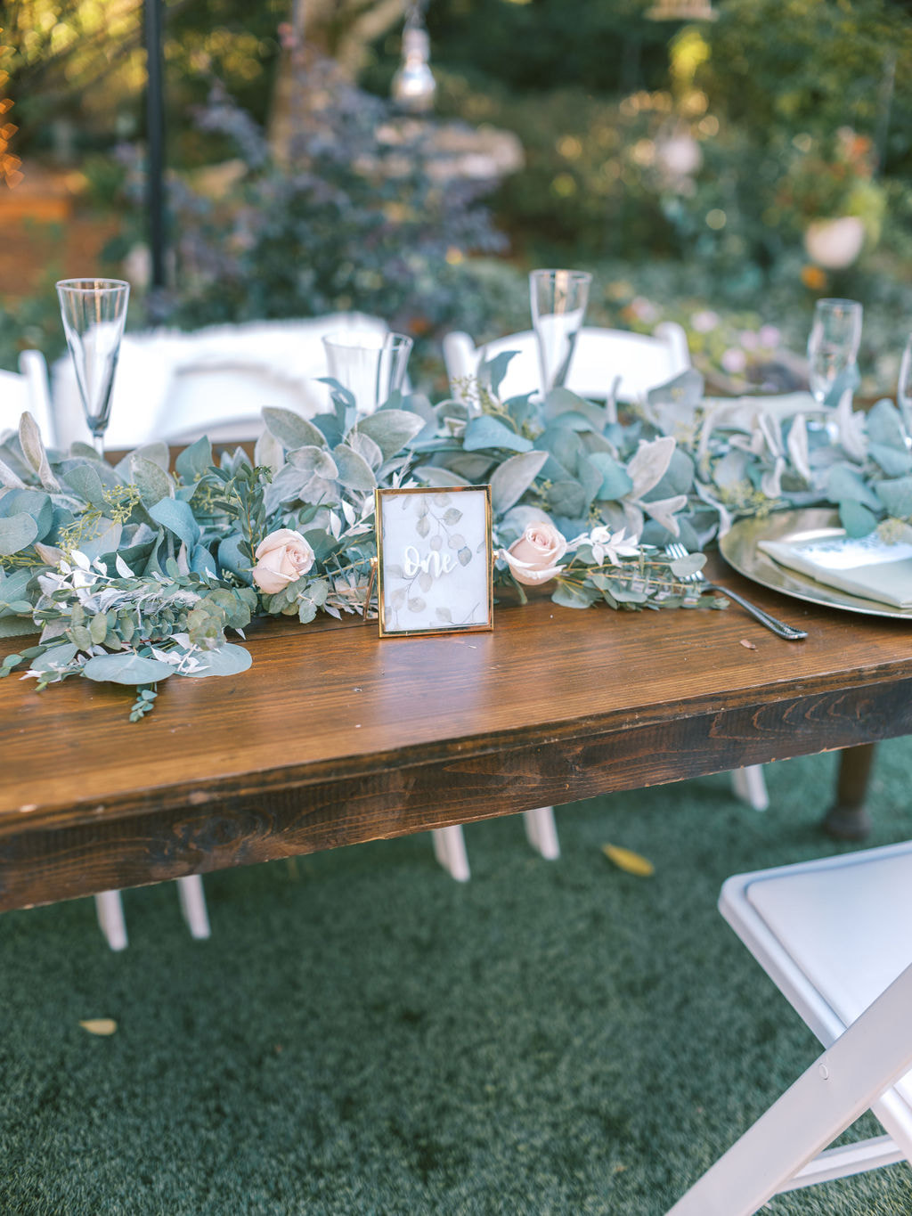mix of faux and real greenery on head table