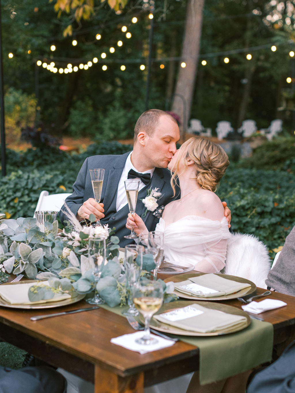 newlyweds kissing at head table