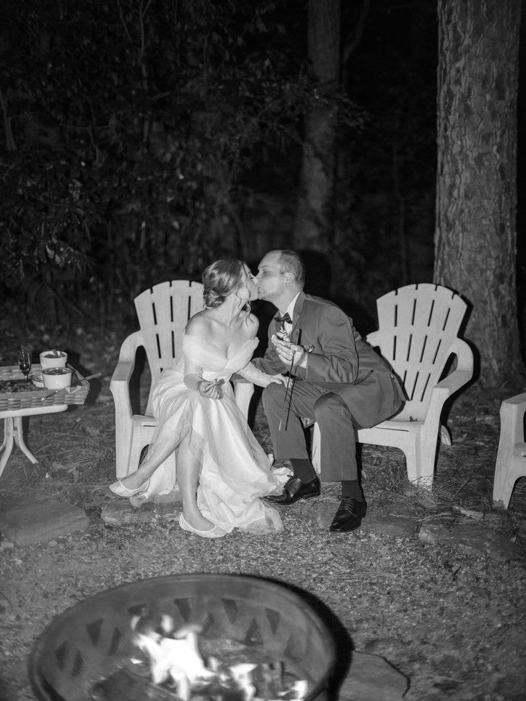 bride and groom kissing at smore's station