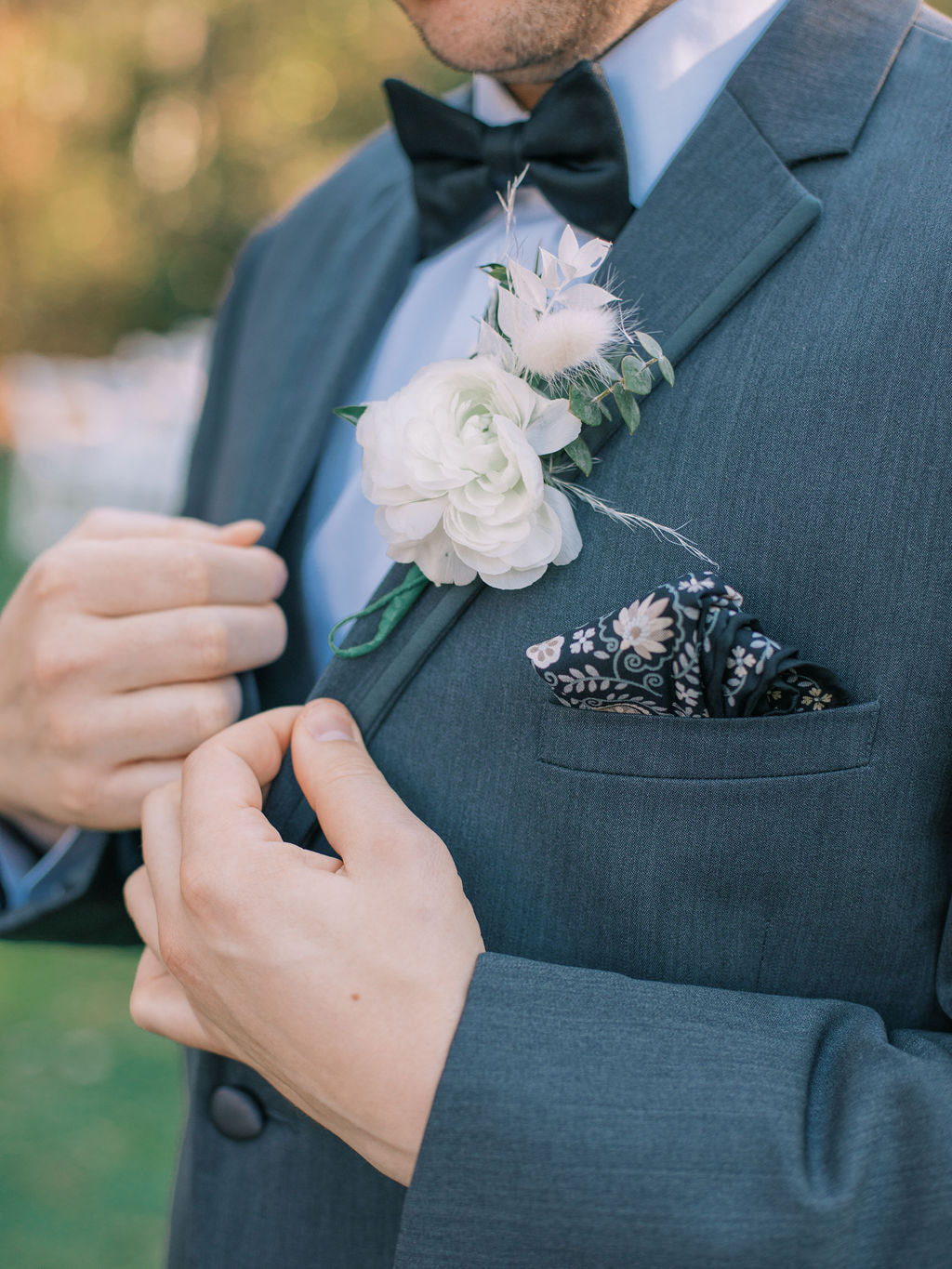 detail photo of groom's suit, pocket square, and boutonniere