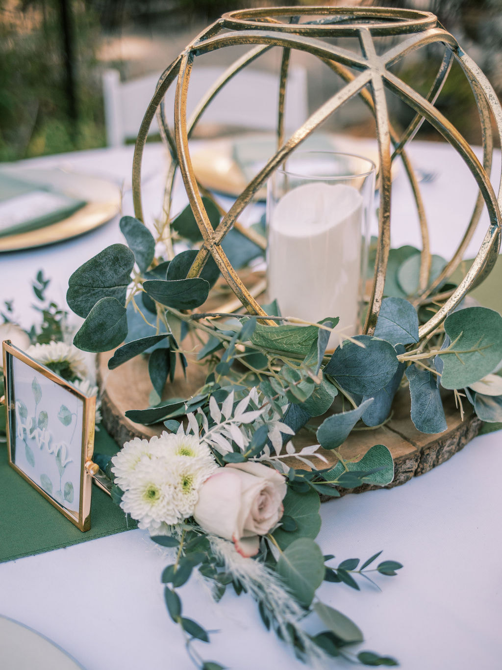 gold geometric centerpiece with greenery and floral arrangement