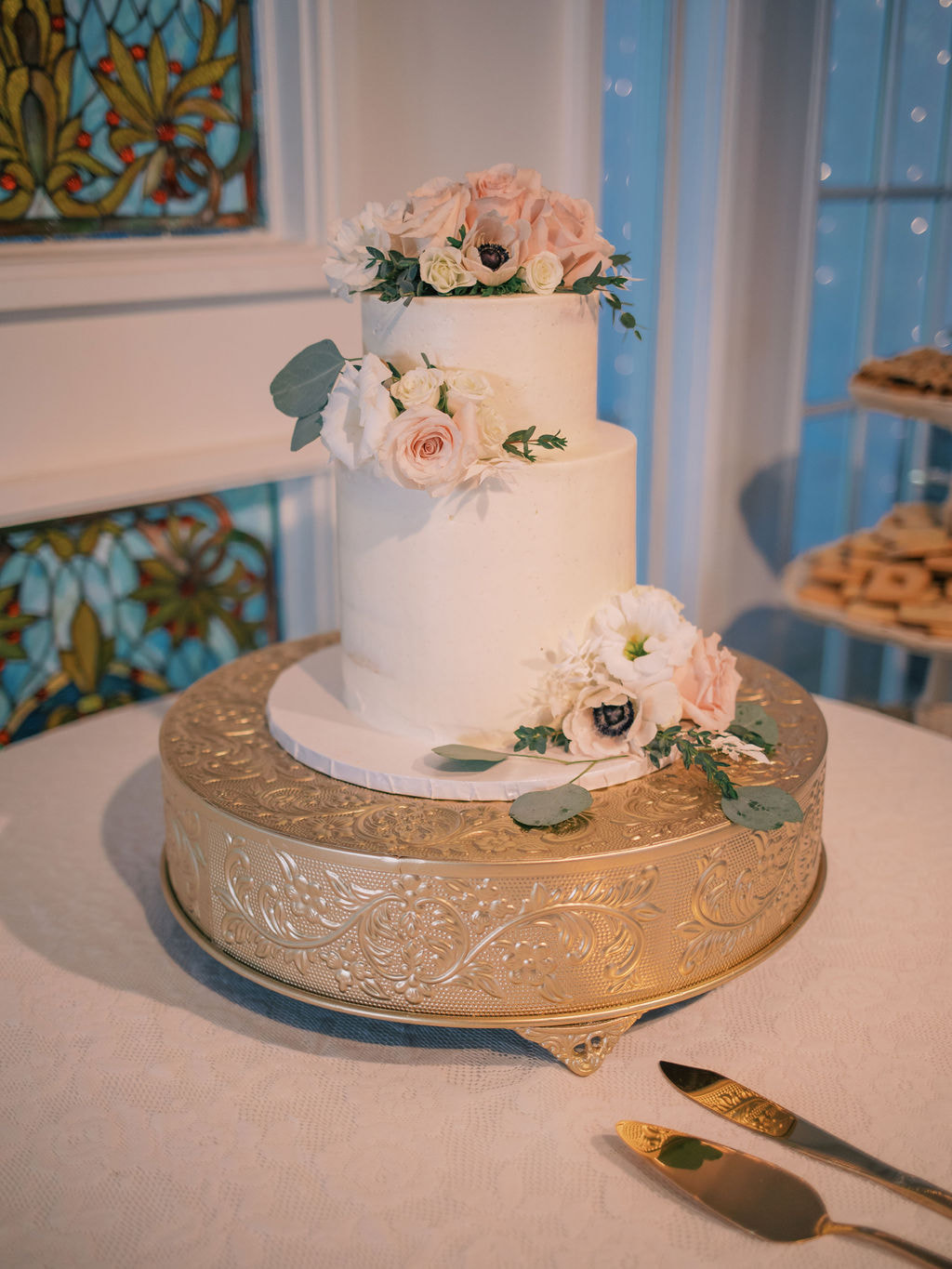 two-tier wedding cake on gold embossed stand