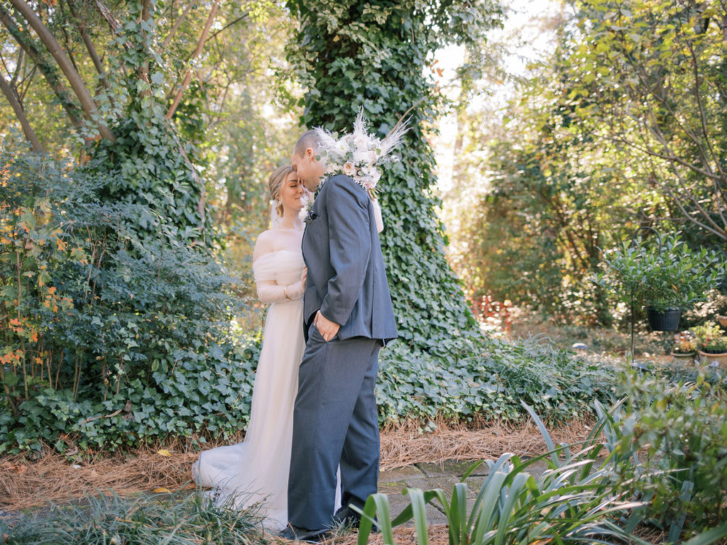 bride and groom posing in ivy covered garden