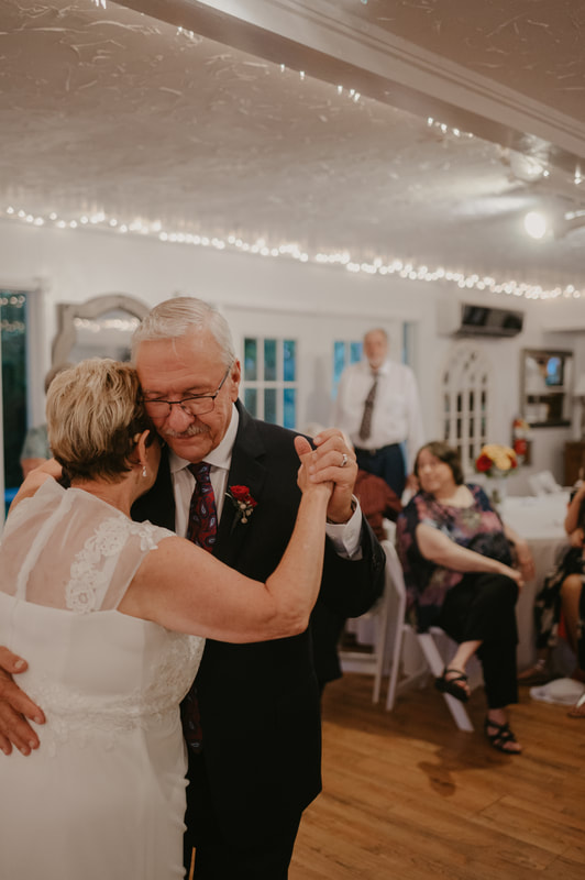 older couple sharing first dance on wedding dance floor