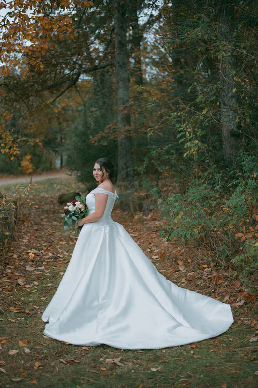 fall bride walking through path surrounded by colorful trees