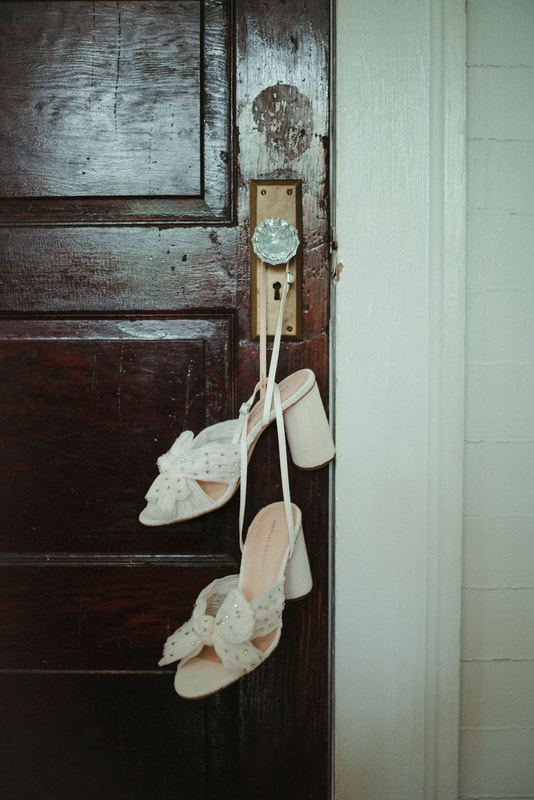 bride's shoes hanging on vintage farmhouse door knob