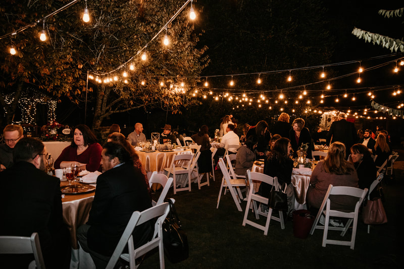 outdoor wedding reception at night under bistro lights
