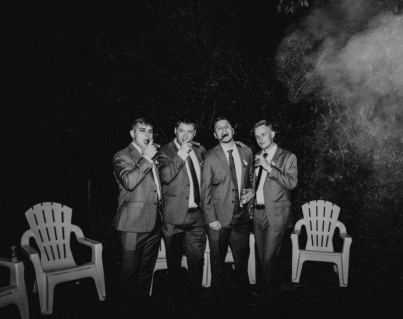 black and white photo of groomsmen smoking cigars