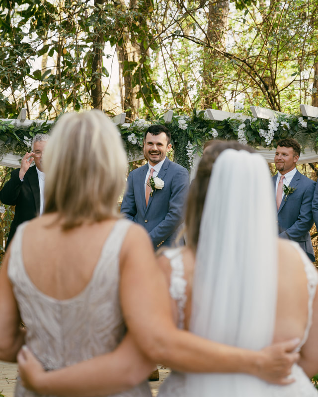 groom reacting to bride walking down aisle