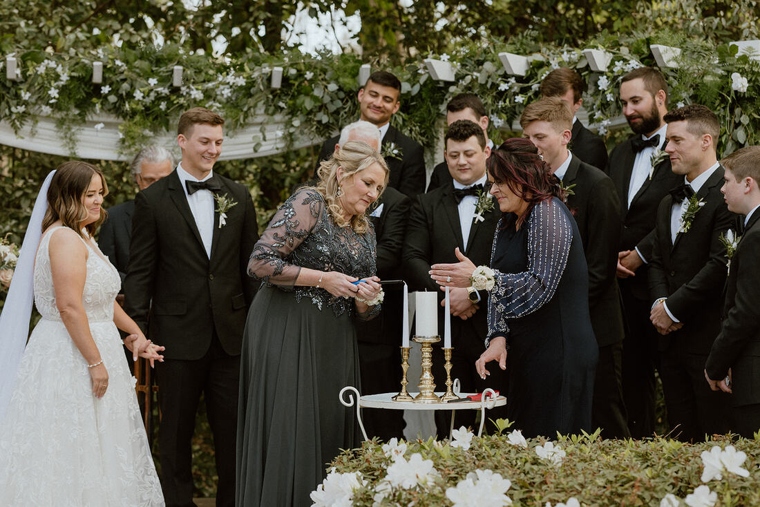 mothers lighting unity candles at garden wedding