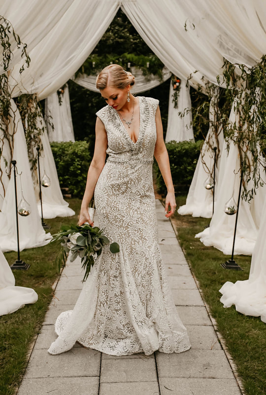 bride posing in vintage dress by altar with bouquet