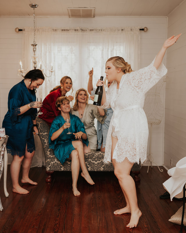 bride and bridesmaids in lace robes celebrating with champagne