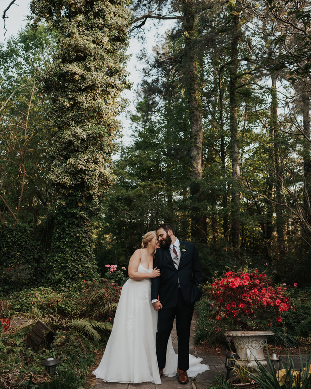 bride and groom surrounded by trees and bright flowers