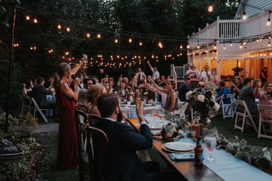 guests raising champagne toast at garden wedding reception