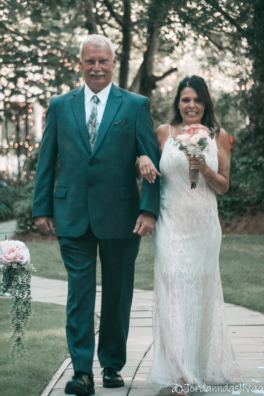 bride excited to walk down aisle while holding father's arm before ceremony