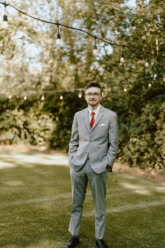 groom in gray suit with rust tie