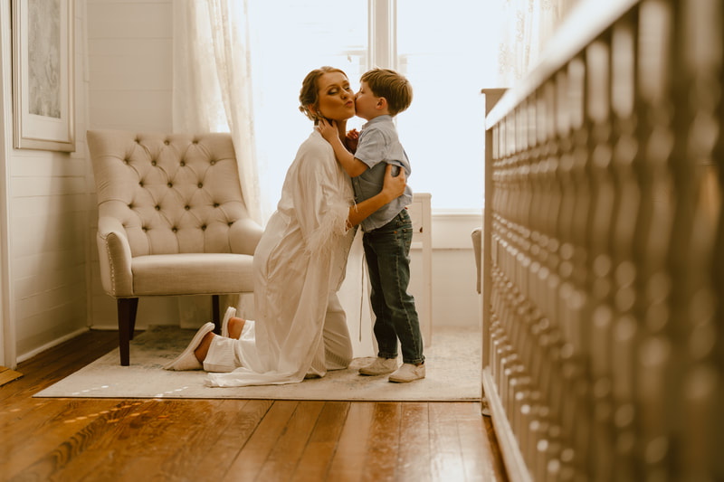 bride's son kissing cheek in bridal suite