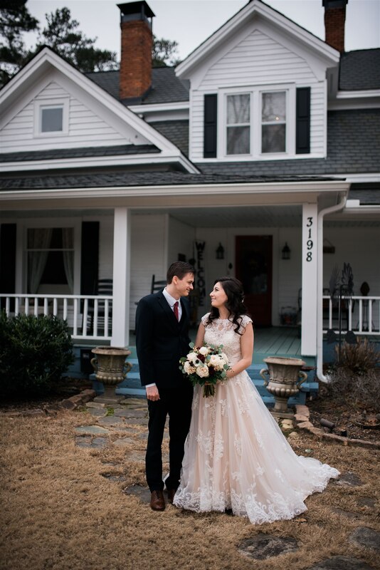 bride and groom standing in front of farmhouse venue