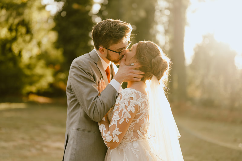 bride and groom kissing during golden hour