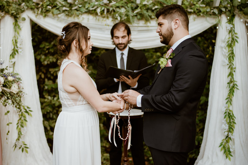 bride and groom performing hand fasting ceremony