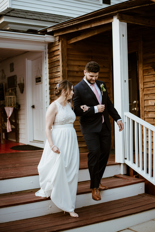 bride and groom walking down farmhouse steps during announcement into reception