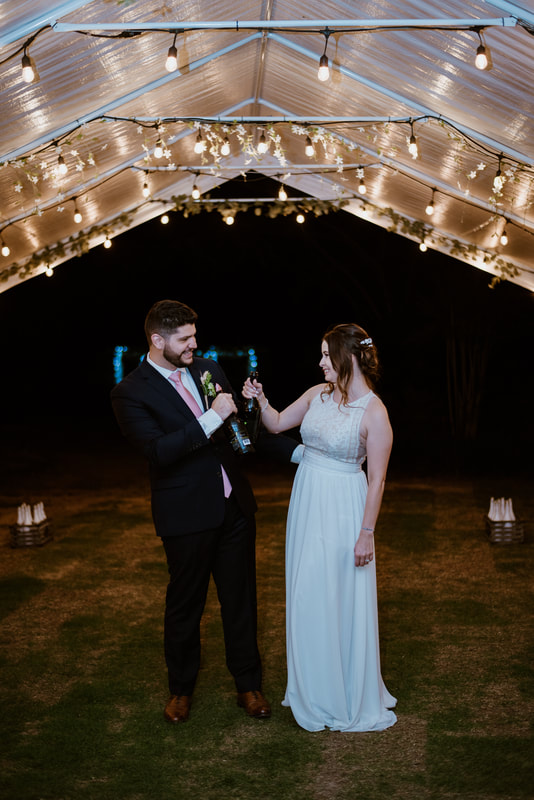 bride and groom toasting under reception tents