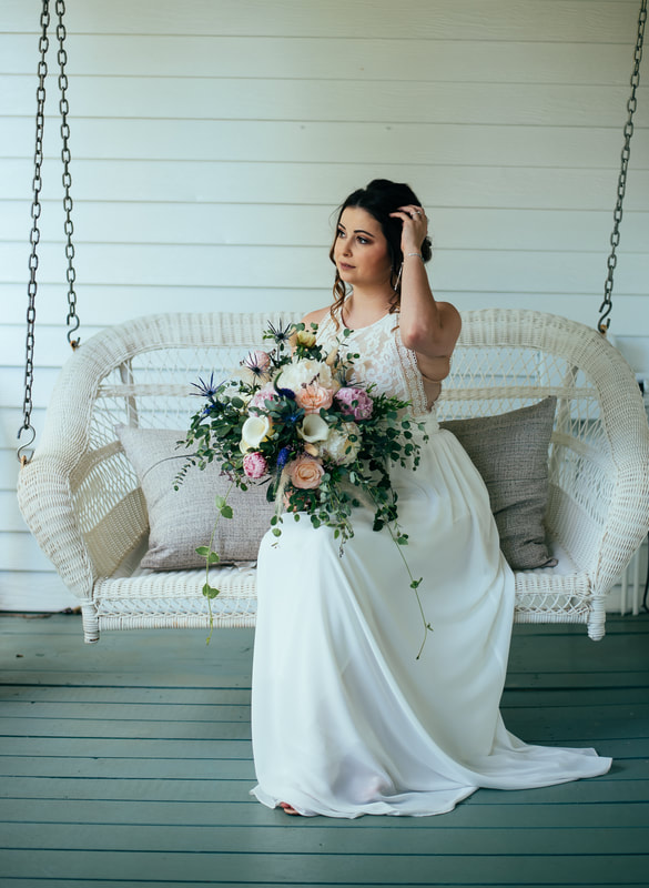 bride sitting on white porch swing