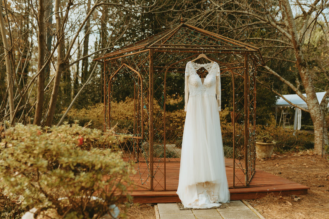 wedding dress hanging on outdoor gazebo