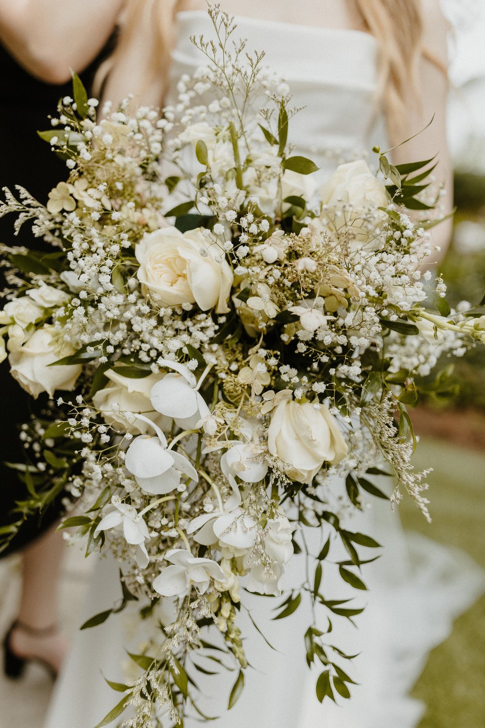 bridal bouquet with white roses, baby's breath, and greenery