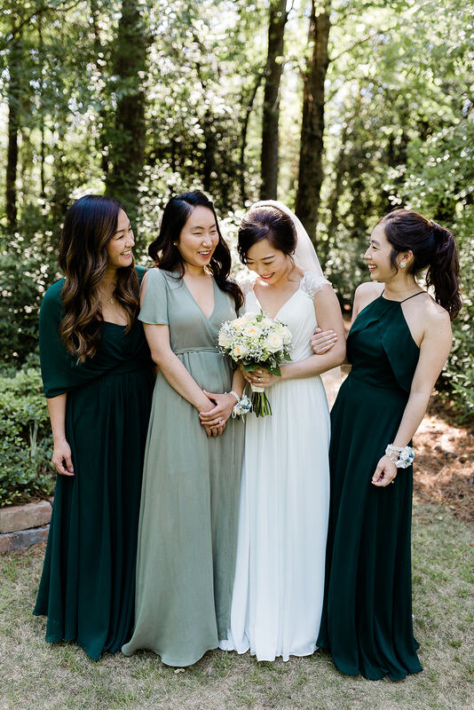 bride with sisters in sage and emerald dresses laughing